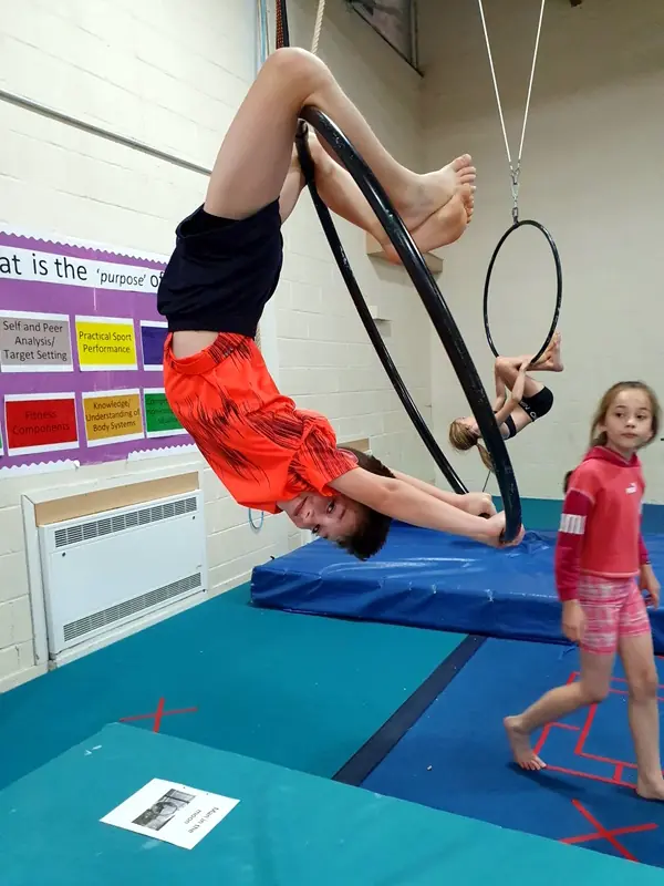 child practising aerial hoop in circus class