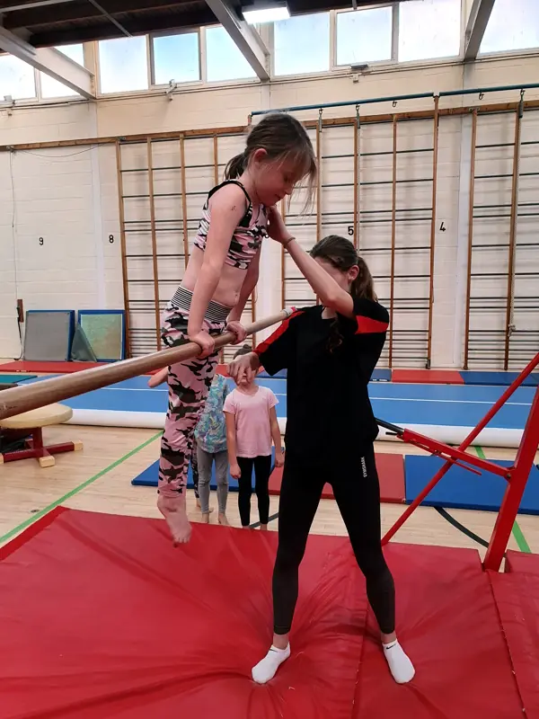 gymnast on bar with coach